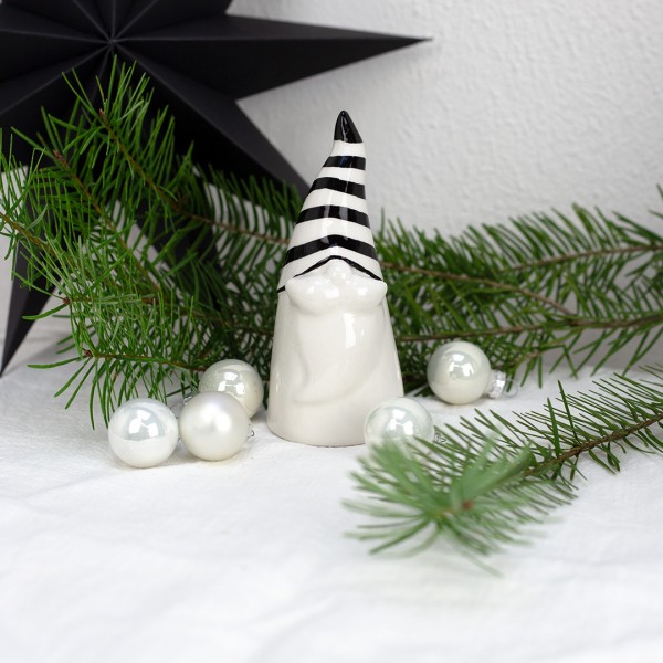 Kleiner Wichtel aus Keramik mit Weihnachtsdeko im Hintergrund