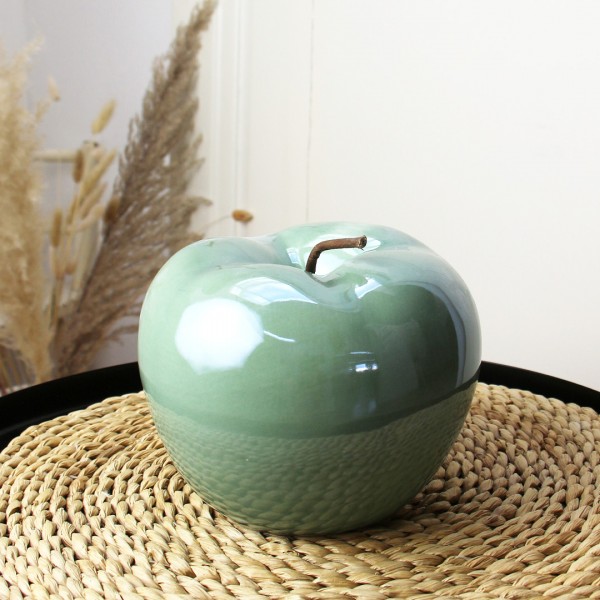 grüner Deko-Apfel auf kleinem schwarzem Tisch