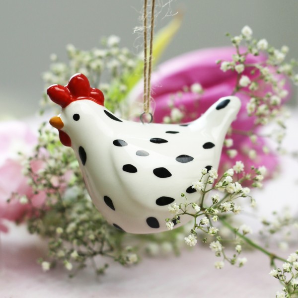 Keramik-Huhn vor Blumenschmuck